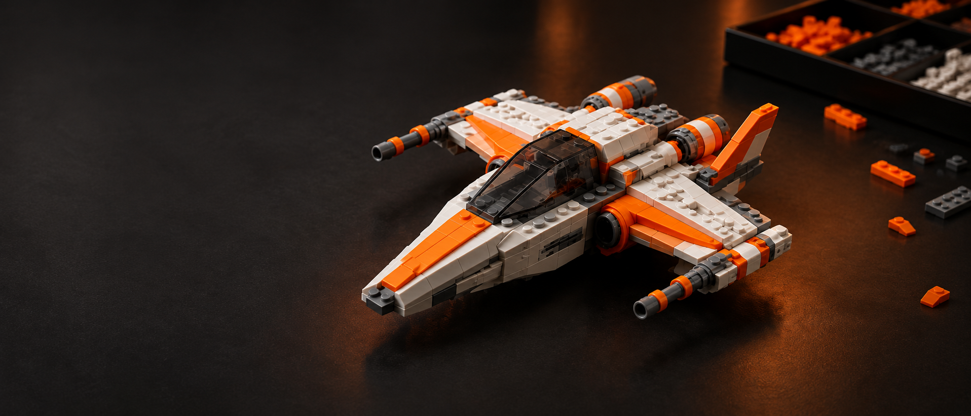 An orange and white brick-built spacecraft beside trays of sorted pieces.